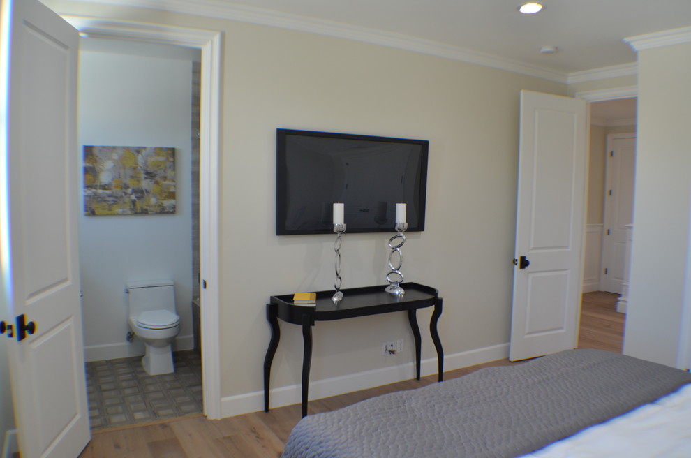 Diseño de habitación de invitados clásica de tamaño medio sin chimenea con paredes beige, suelo de madera clara y suelo marrón