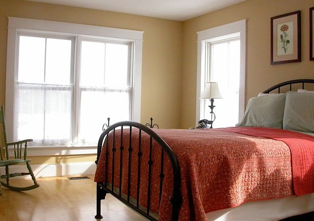 ミルウォーキーにある中くらいなトラディショナルスタイルのおしゃれな主寝室 (黄色い壁、淡色無垢フローリング、暖炉なし) のインテリア