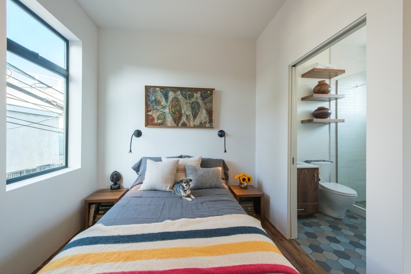 Kleines Modernes Schlafzimmer ohne Kamin, im Loft-Style mit weißer Wandfarbe und braunem Holzboden in Los Angeles