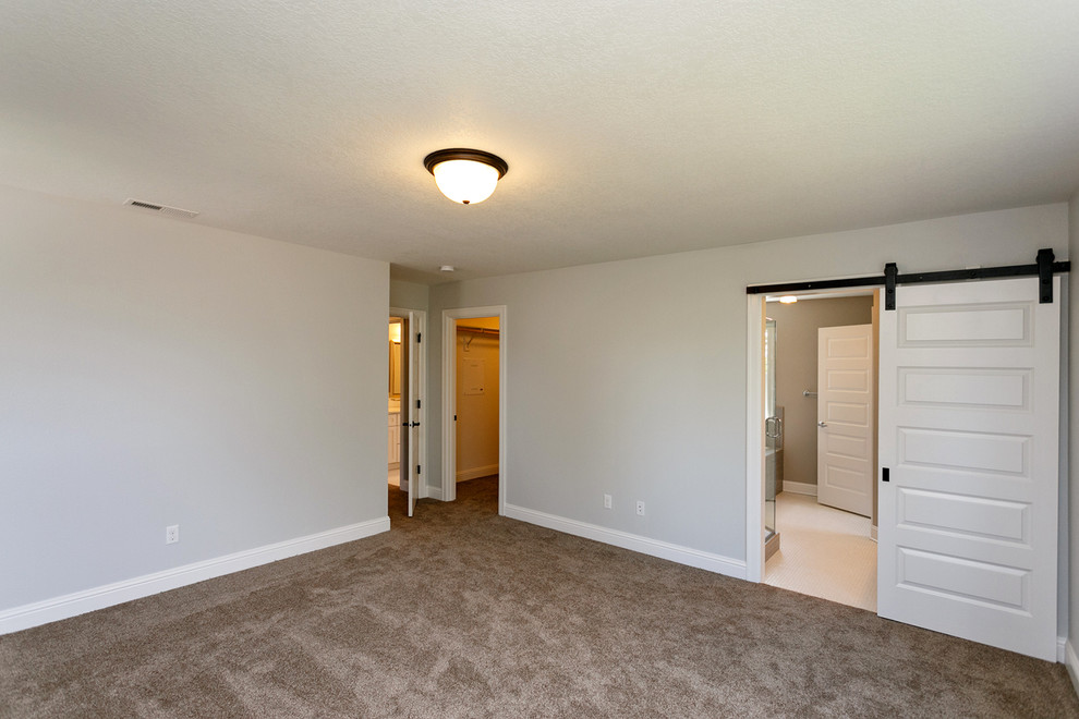 Ejemplo de dormitorio principal de estilo americano de tamaño medio con paredes grises y moqueta