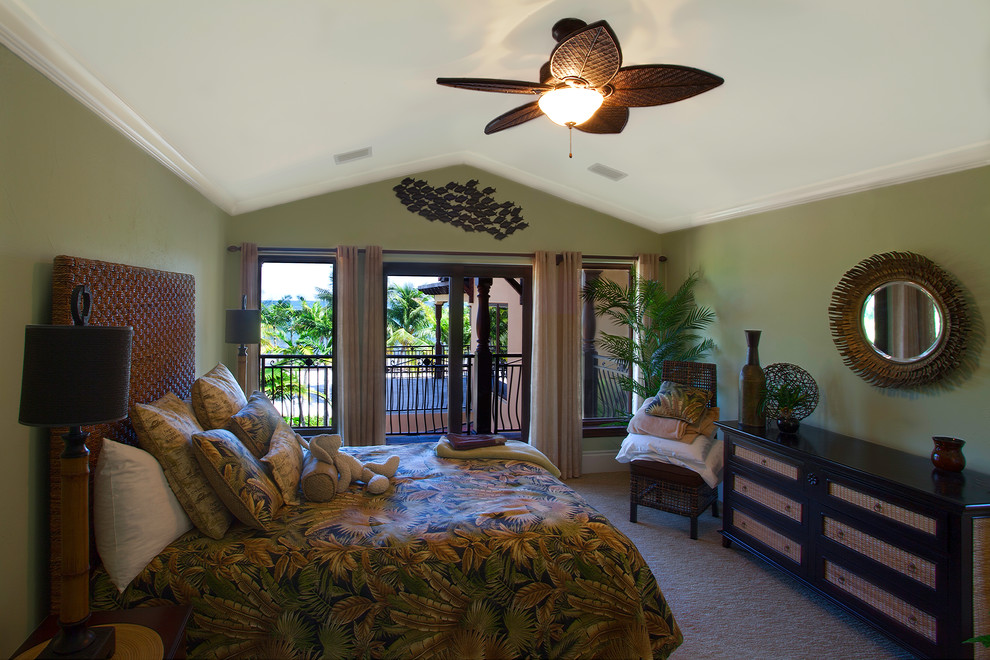 Esempio di una grande camera degli ospiti tropicale con pareti verdi, pavimento in travertino e pavimento beige