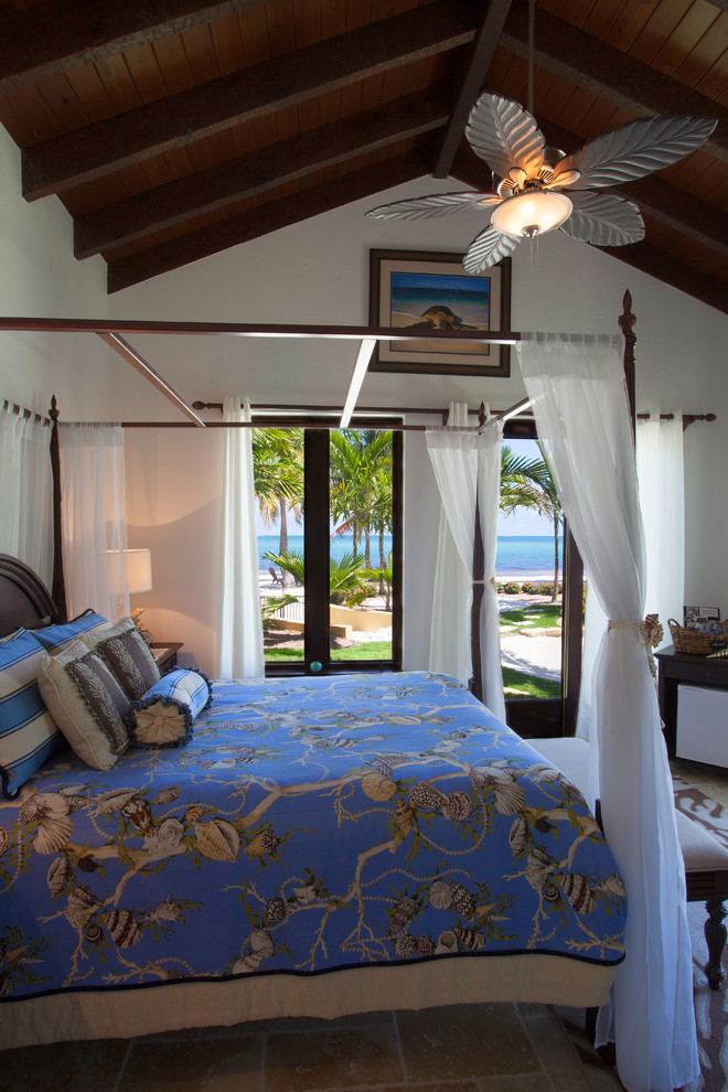 Idee per una grande camera degli ospiti tropicale con pareti blu, pavimento in travertino e pavimento beige