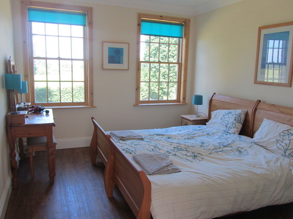 Foto de habitación de invitados de estilo de casa de campo grande sin chimenea con paredes beige y suelo de bambú