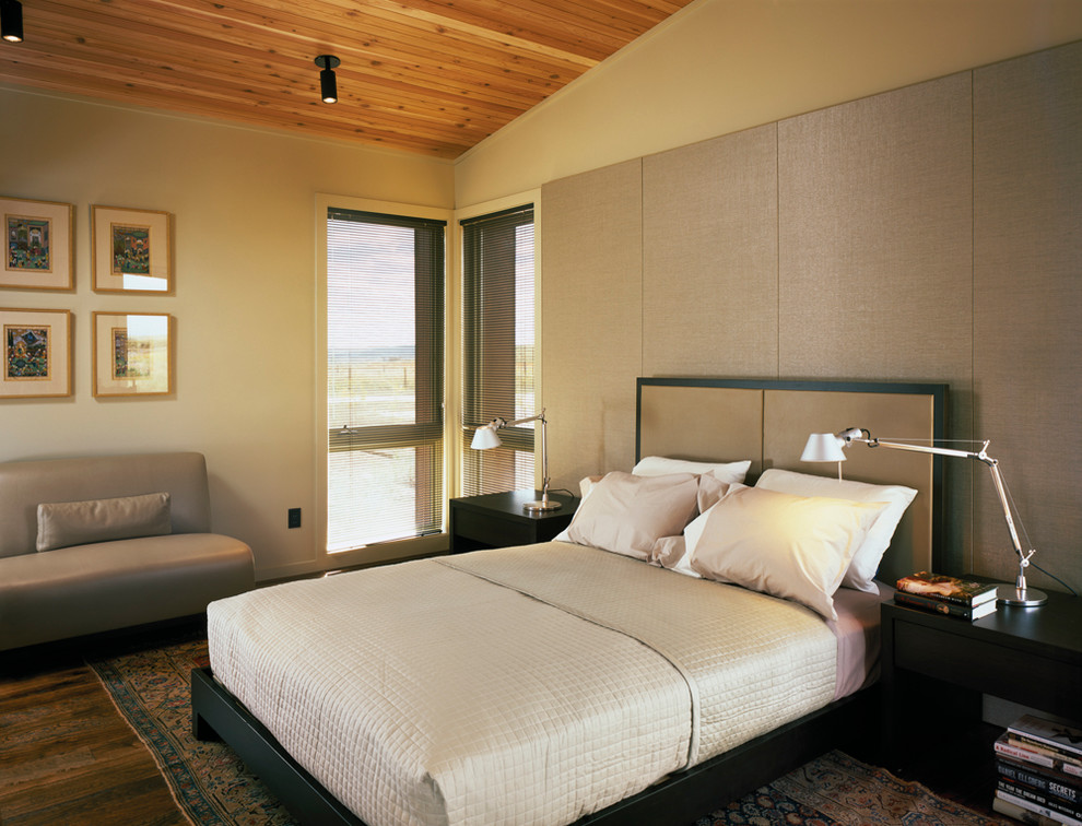 Idée de décoration pour une chambre chalet avec un mur beige et parquet foncé.