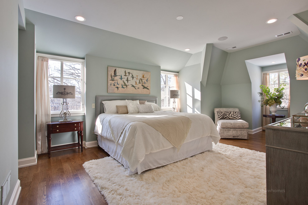 Diseño de dormitorio principal tradicional de tamaño medio con paredes verdes y suelo de madera clara