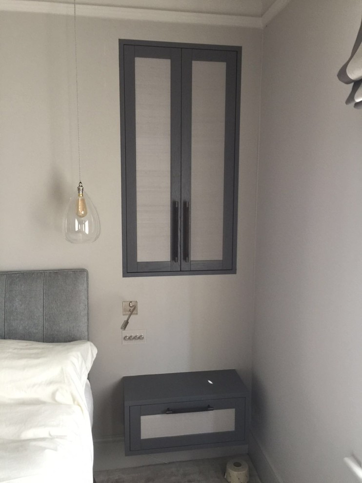 Cette image montre une grande chambre parentale minimaliste avec un mur gris, parquet clair et aucune cheminée.