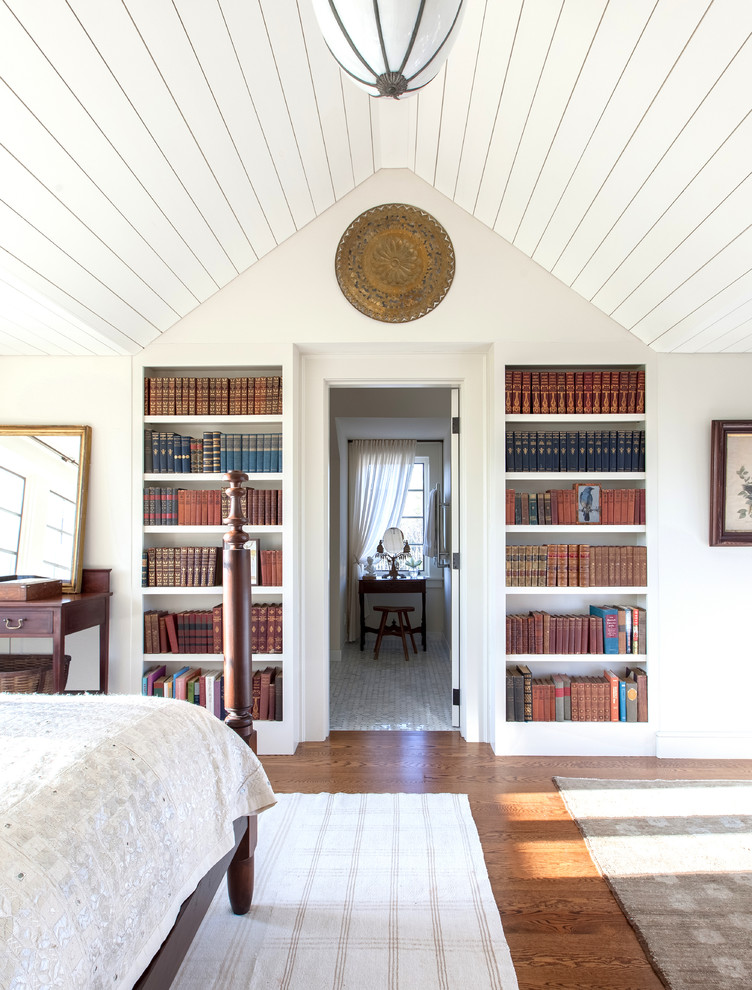 Imagen de dormitorio principal tradicional con paredes blancas, suelo de madera en tonos medios y suelo marrón