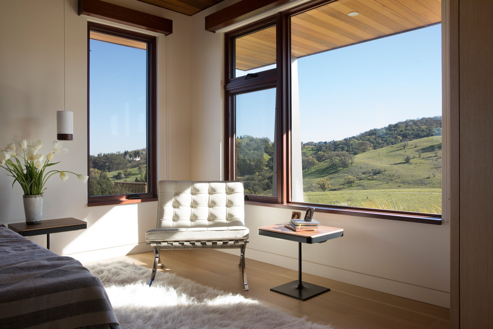 Imagen de dormitorio minimalista grande con paredes blancas, suelo de madera clara y suelo beige