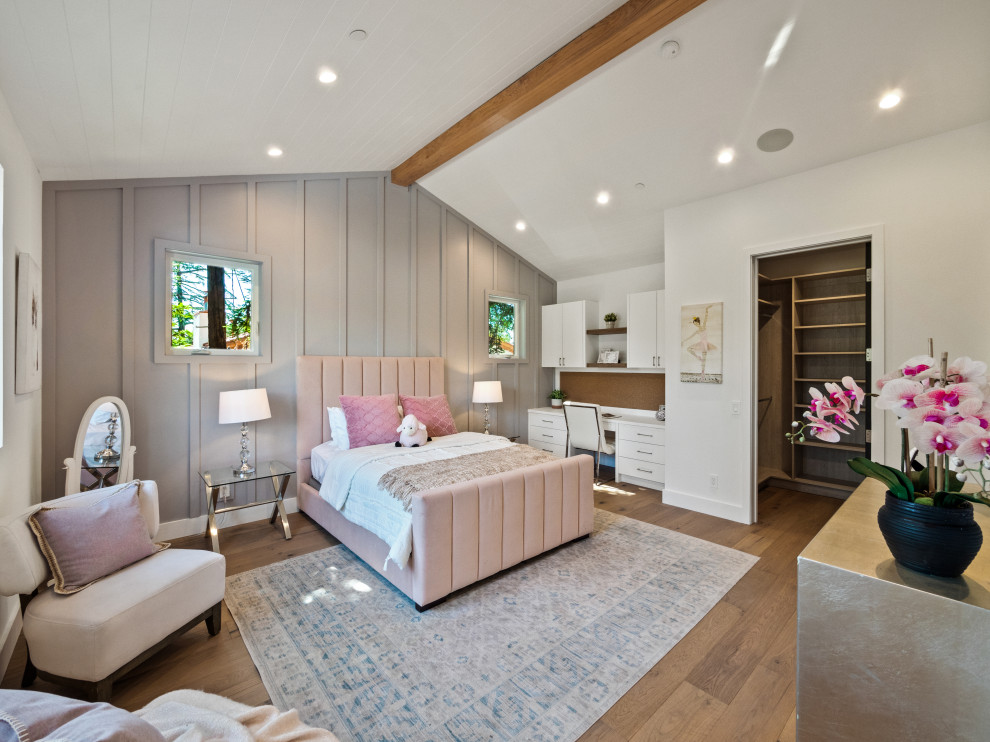 Large farmhouse guest bedroom in Los Angeles with no fireplace, a vaulted ceiling and panelled walls.