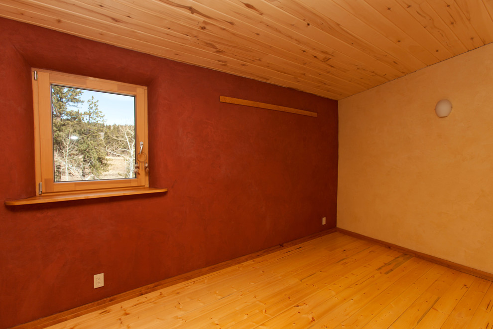 Exemple d'une chambre parentale avec un mur rouge et parquet clair.