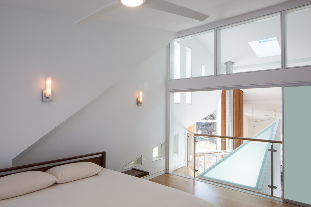 Esempio di una camera da letto stile loft moderna di medie dimensioni con pareti beige, pavimento in bambù e nessun camino
