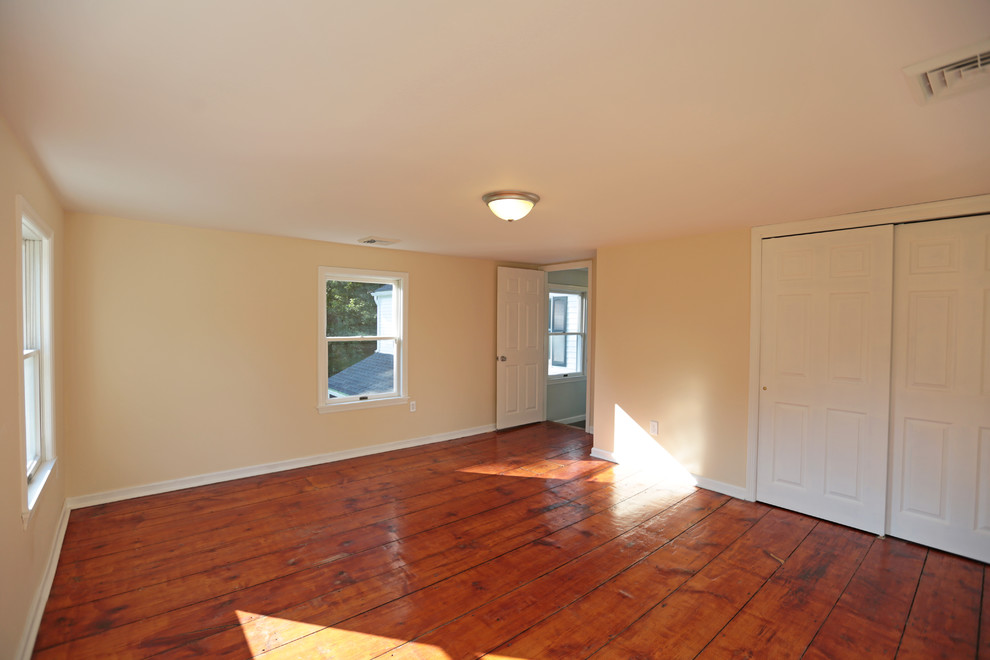 Immagine di una camera degli ospiti chic di medie dimensioni con pareti beige, parquet scuro e nessun camino
