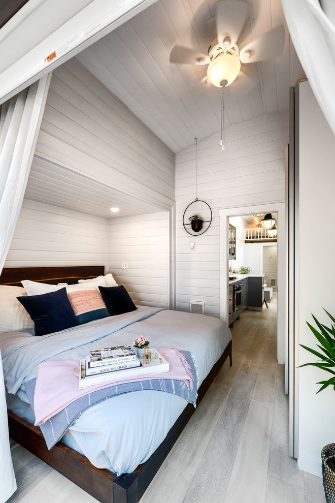 Diseño de dormitorio tradicional renovado con paredes blancas, suelo de madera clara y suelo blanco