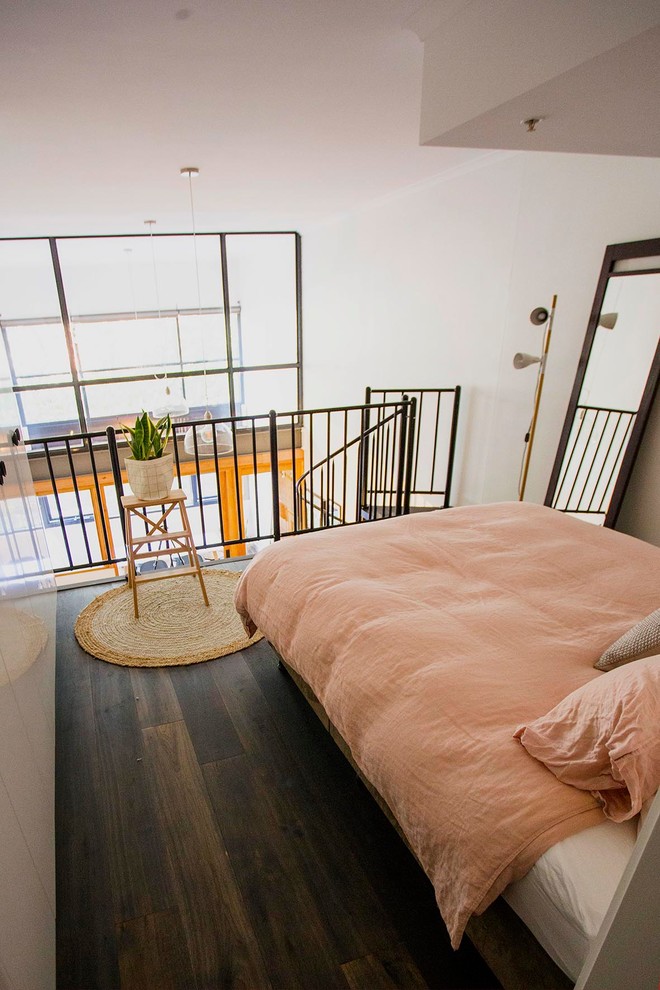 Foto di una camera da letto stile loft industriale di medie dimensioni con pareti bianche, parquet scuro, nessun camino e pavimento grigio