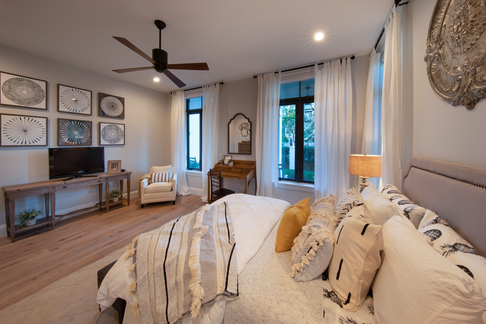 マイアミにある広いトランジショナルスタイルのおしゃれな客用寝室 (無垢フローリング、茶色い床、グレーの壁)
