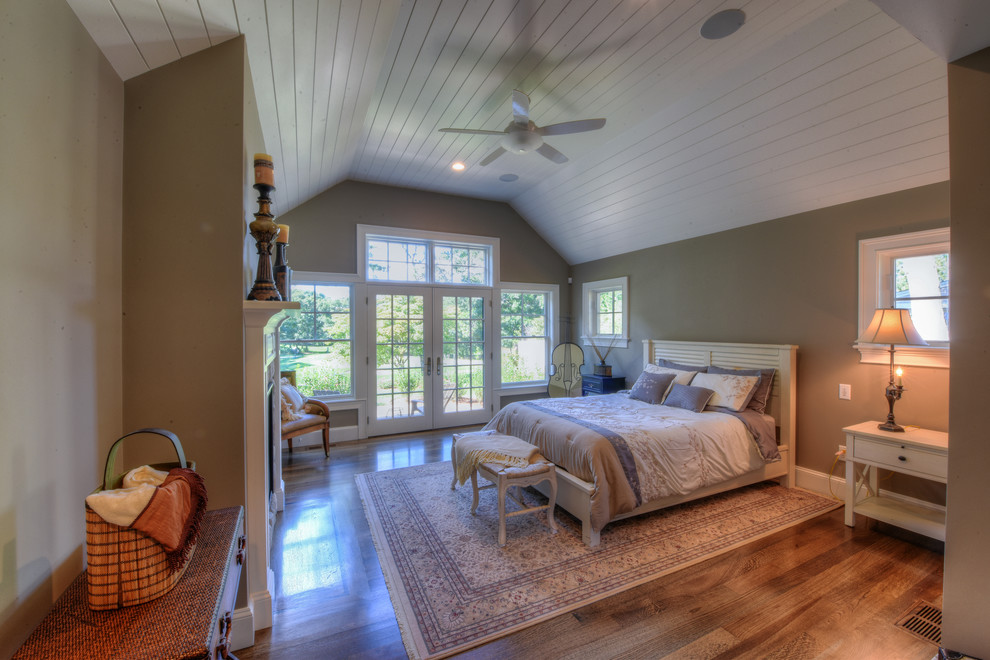 Imagen de dormitorio principal tradicional grande con paredes beige, suelo de madera en tonos medios, todas las chimeneas y marco de chimenea de madera
