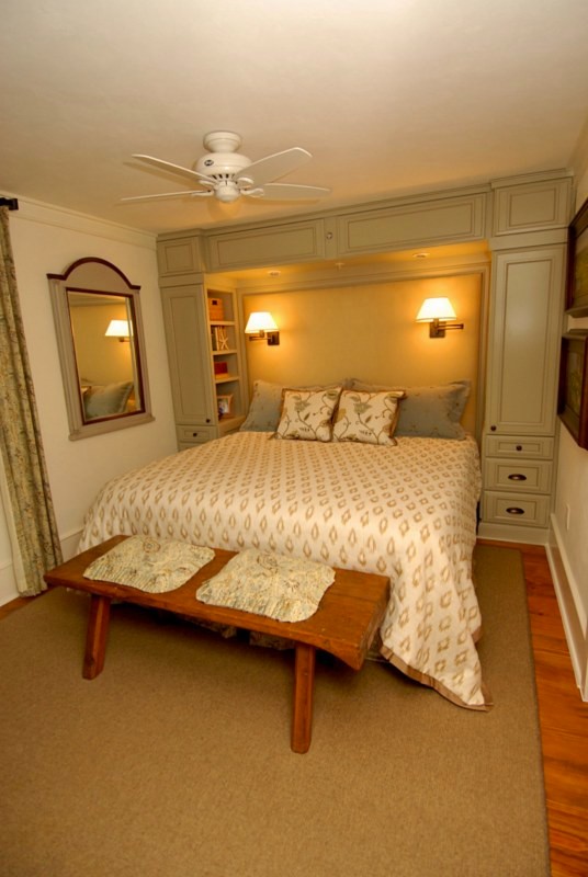 Diseño de dormitorio principal clásico pequeño sin chimenea con paredes blancas y suelo de madera en tonos medios