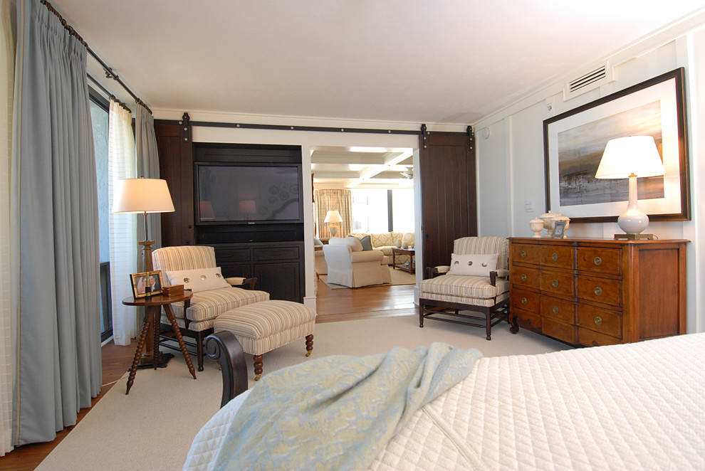 Photo of a large coastal master bedroom in Orlando with white walls and medium hardwood flooring.