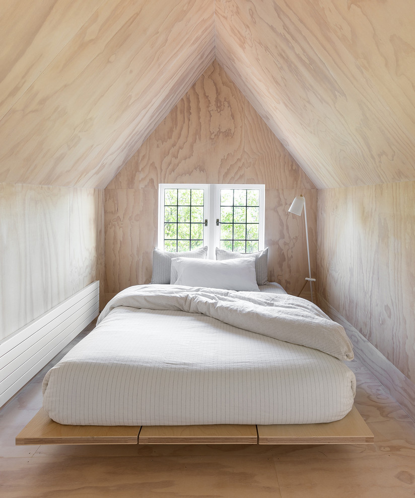 Inredning av ett minimalistiskt litet gästrum, med plywoodgolv, beige väggar och beiget golv