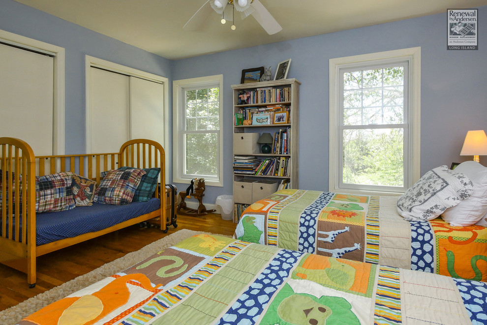 Imagen de habitación de invitados clásica sin chimenea con paredes azules y suelo de madera en tonos medios