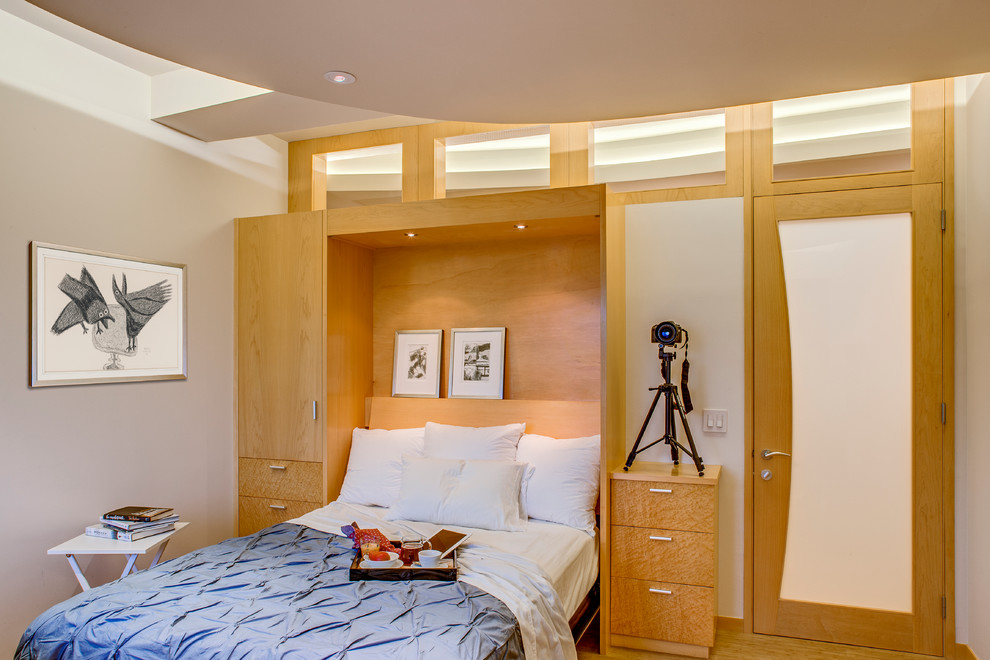 Diseño de habitación de invitados actual de tamaño medio con paredes blancas, suelo de madera en tonos medios y suelo beige