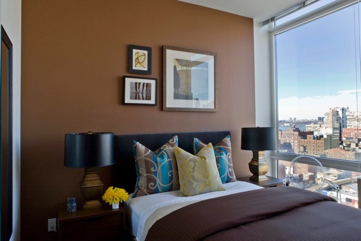 Imagen de dormitorio principal bohemio de tamaño medio sin chimenea con parades naranjas y suelo de madera en tonos medios