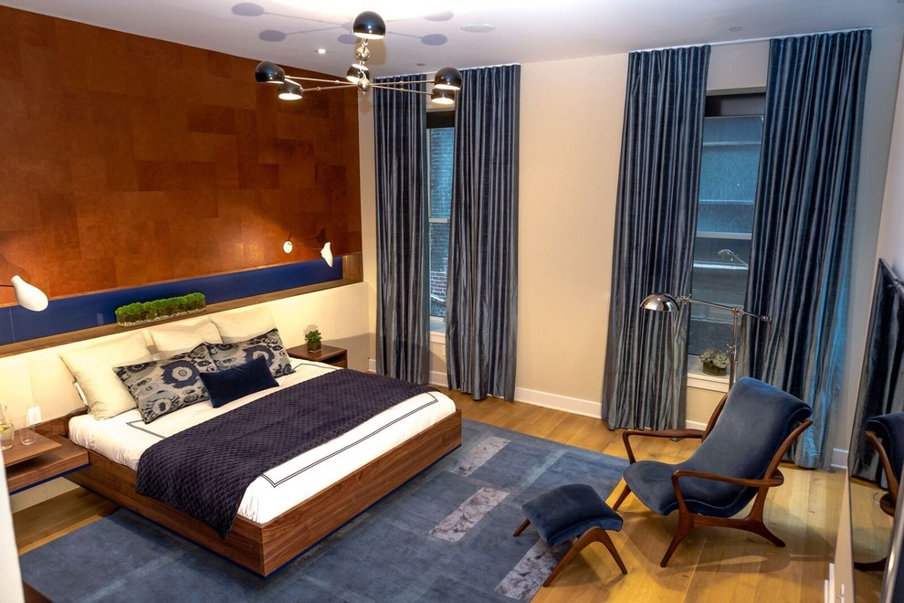 Ejemplo de dormitorio principal moderno grande sin chimenea con suelo de madera clara y paredes beige