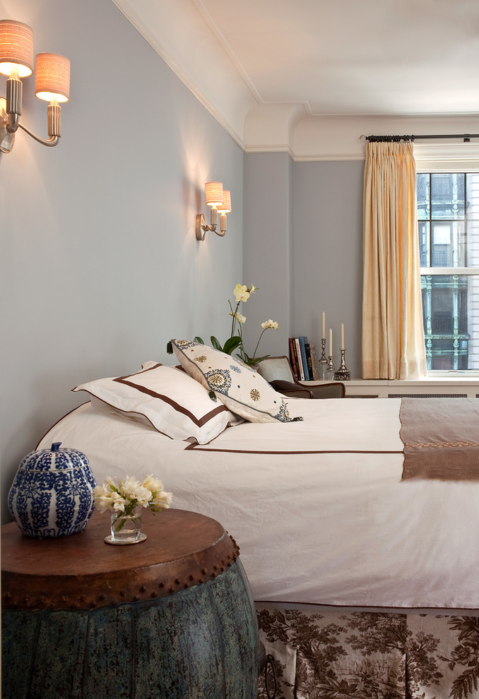 Large elegant master medium tone wood floor bedroom photo in New York with blue walls