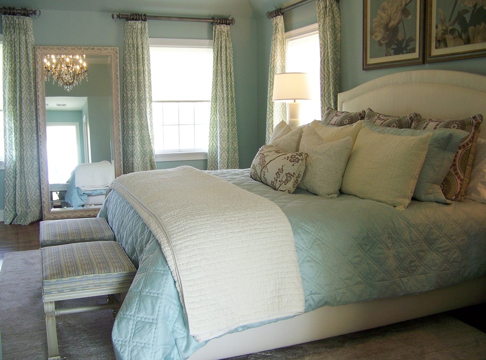 Cette photo montre une chambre parentale de taille moyenne avec un mur bleu, un sol en bois brun et aucune cheminée.