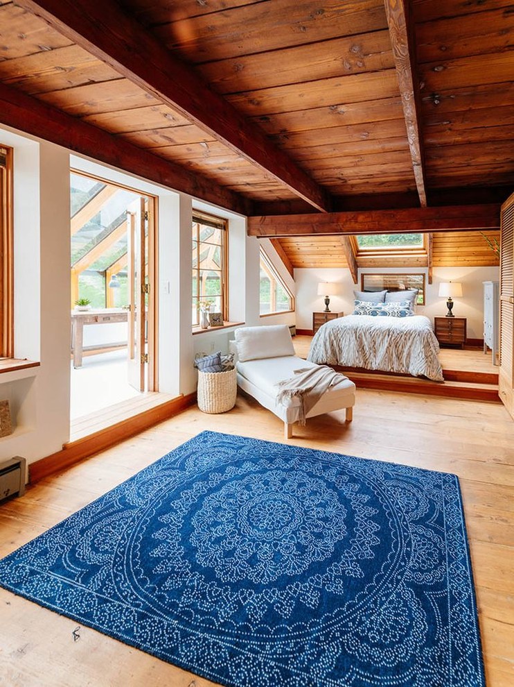 Ejemplo de dormitorio principal exótico con paredes blancas, suelo de madera en tonos medios y suelo marrón