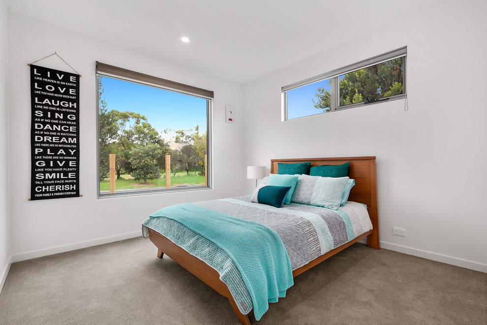 メルボルンにある中くらいなコンテンポラリースタイルのおしゃれな客用寝室 (白い壁、カーペット敷き)
