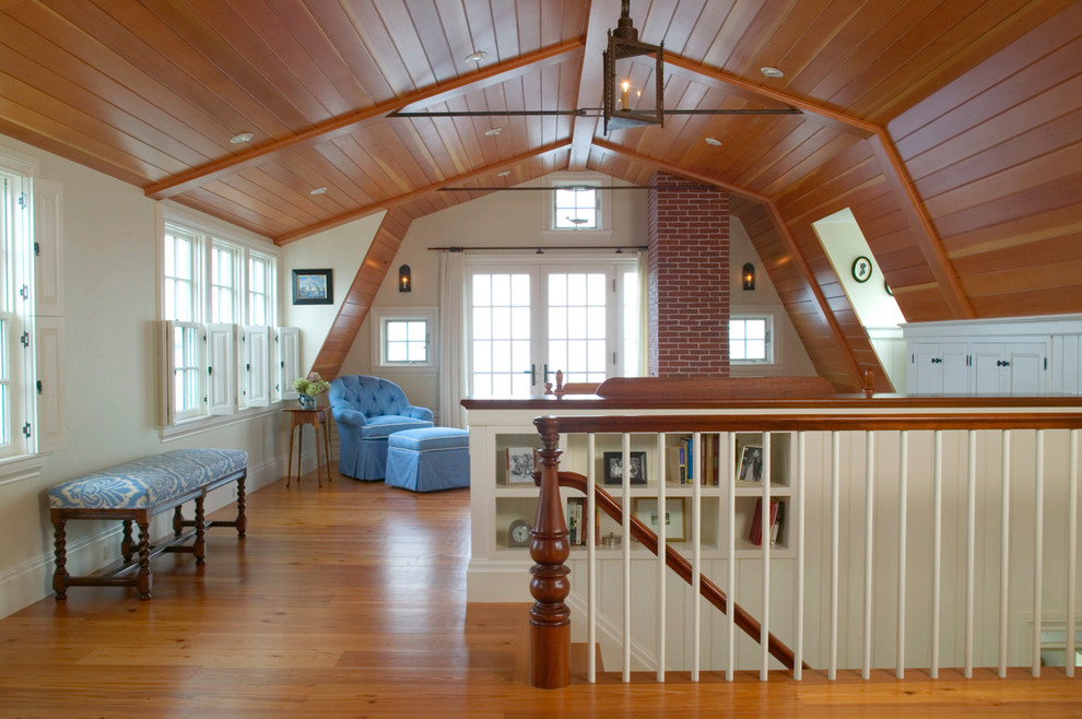 Inspiration for a large rustic mezzanine loft bedroom in Boston with beige walls, medium hardwood flooring, a standard fireplace, a brick fireplace surround and brown floors.