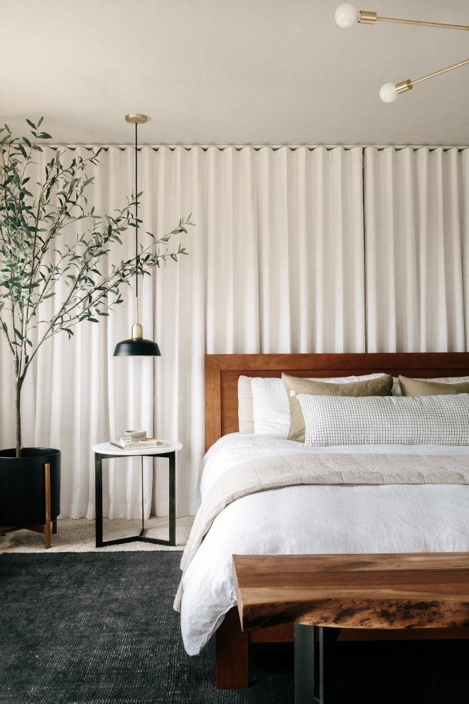 На фото: большая хозяйская спальня в стиле модернизм с серыми стенами, ковровым покрытием, двусторонним камином, фасадом камина из плитки и бежевым полом