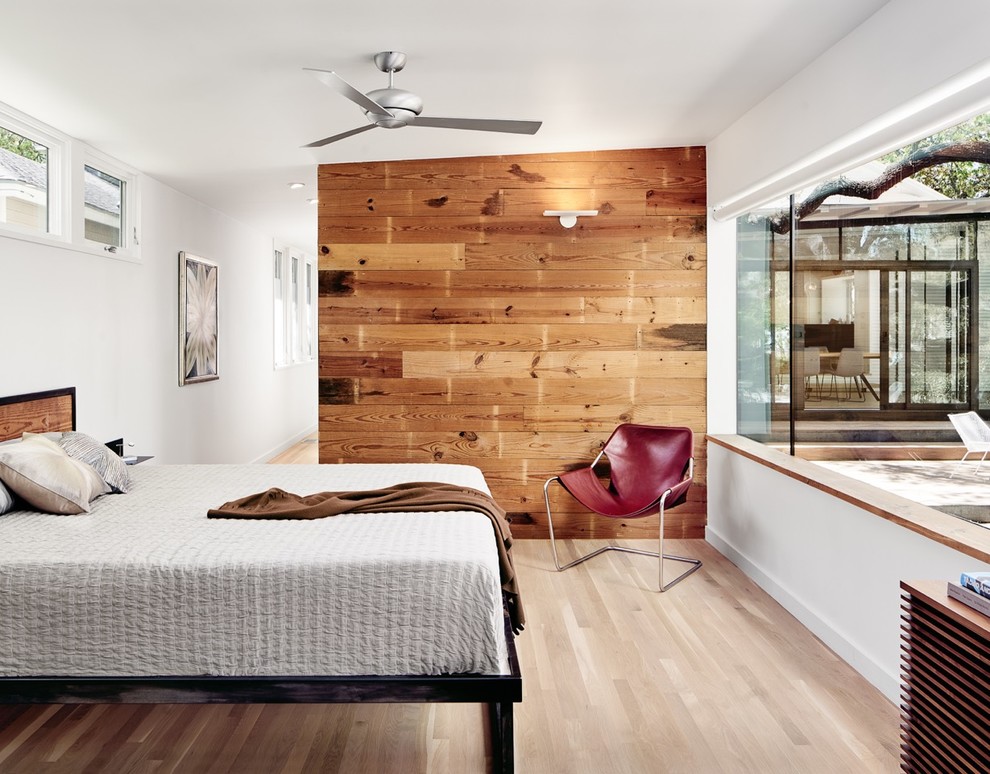 Diseño de habitación de invitados rural sin chimenea con paredes blancas, suelo de madera clara y suelo beige
