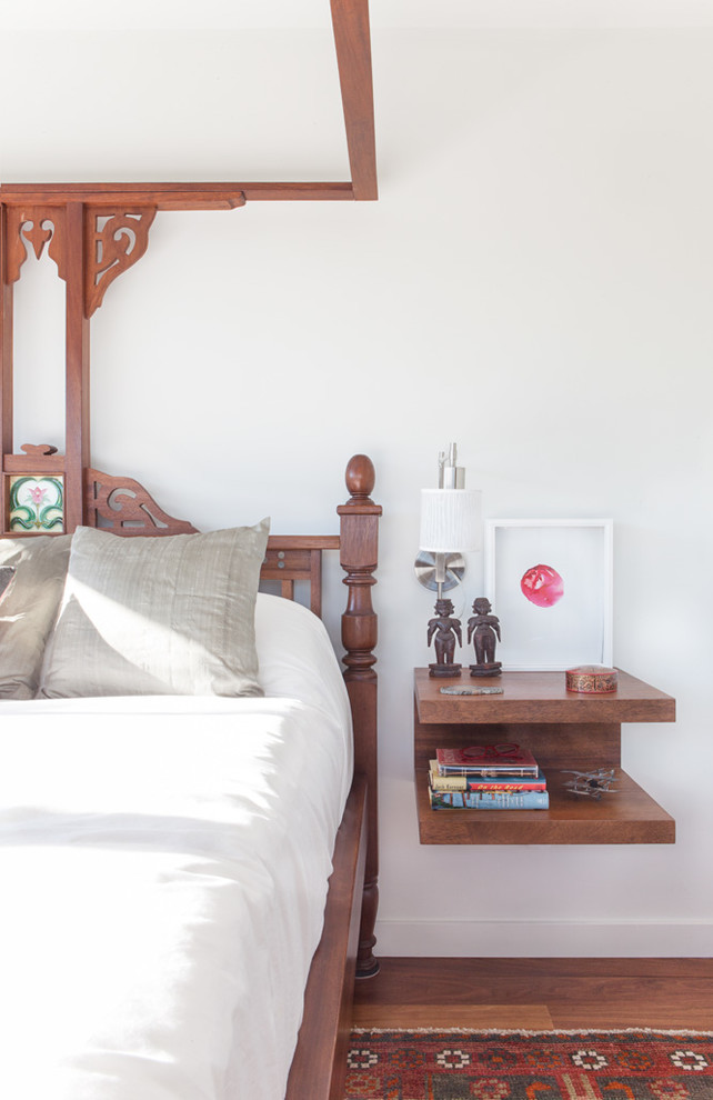 Photo of a world-inspired bedroom in Austin with white walls and medium hardwood flooring.