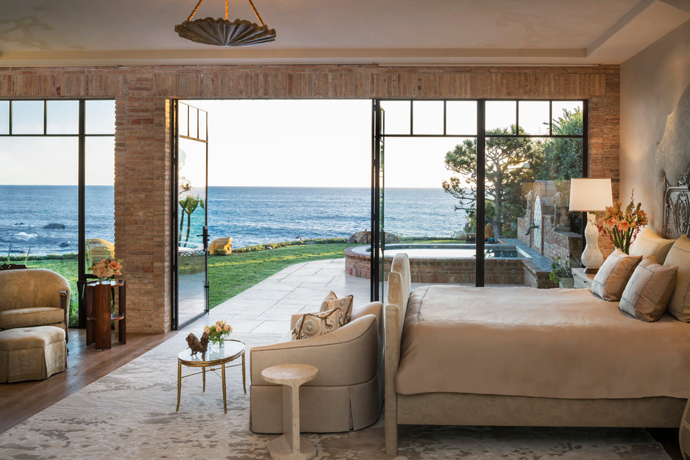 Foto di una camera da letto mediterranea con pareti beige e pavimento in legno massello medio