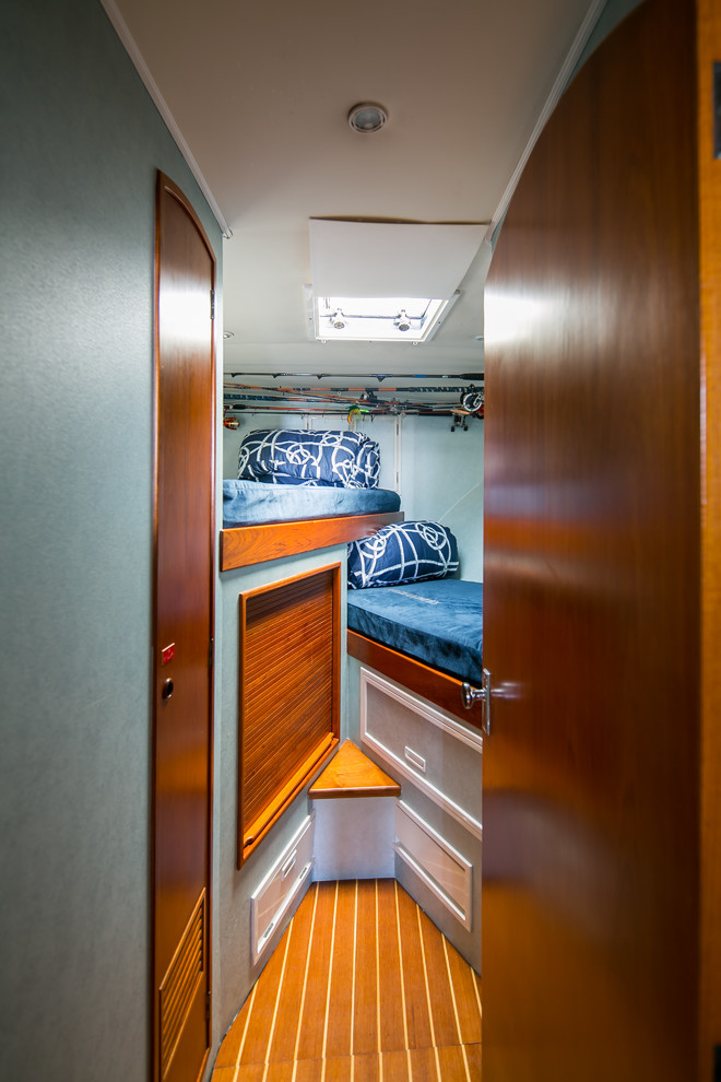 Esempio di una piccola camera degli ospiti stile marinaro con pareti blu, pavimento in legno massello medio e pavimento arancione