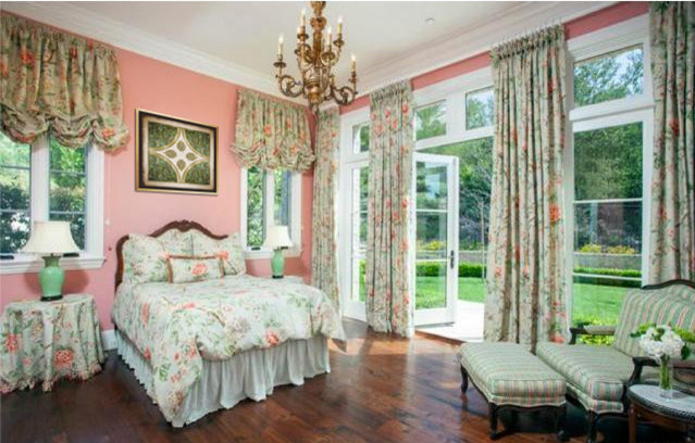 Diseño de dormitorio clásico grande con paredes rosas y suelo de madera oscura