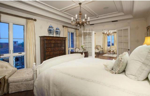Geräumiges Klassisches Schlafzimmer mit weißer Wandfarbe und dunklem Holzboden in Los Angeles