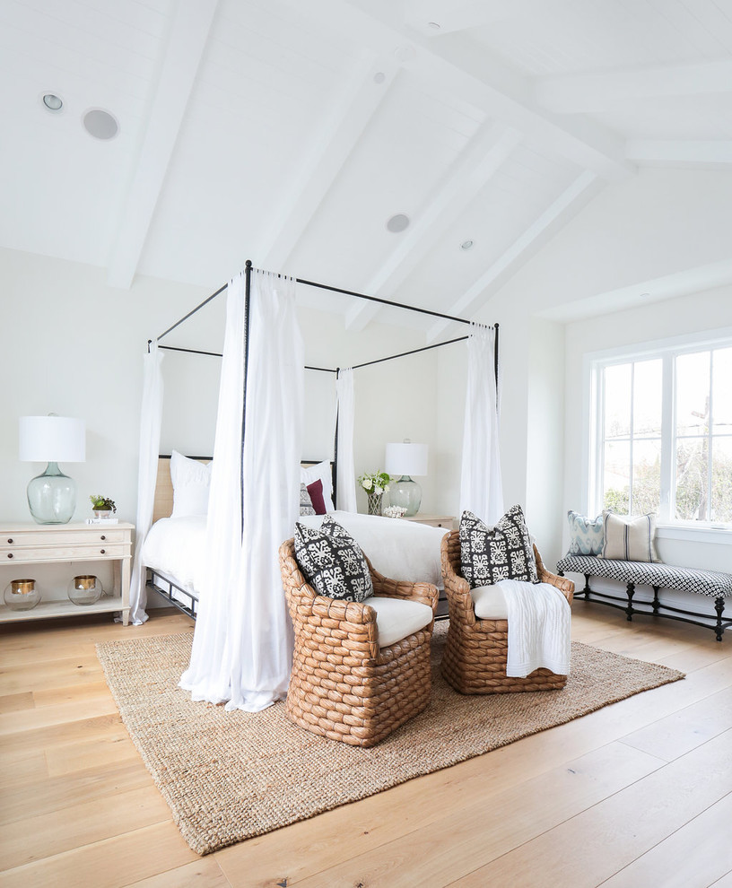 Maritimes Hauptschlafzimmer mit weißer Wandfarbe und hellem Holzboden in Orange County