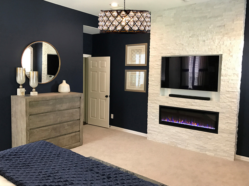 Réalisation d'une grande chambre design avec un mur bleu, une cheminée standard, un manteau de cheminée en pierre et un sol gris.