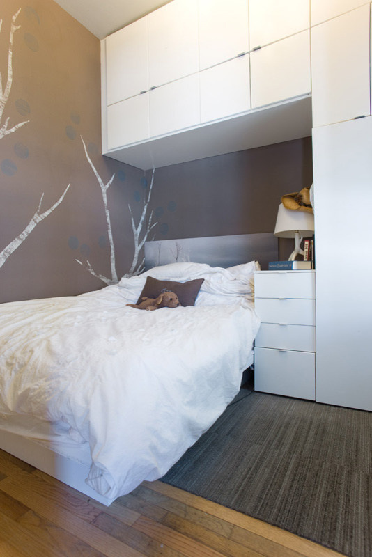 Ejemplo de habitación de invitados moderna pequeña con paredes marrones y suelo de madera clara