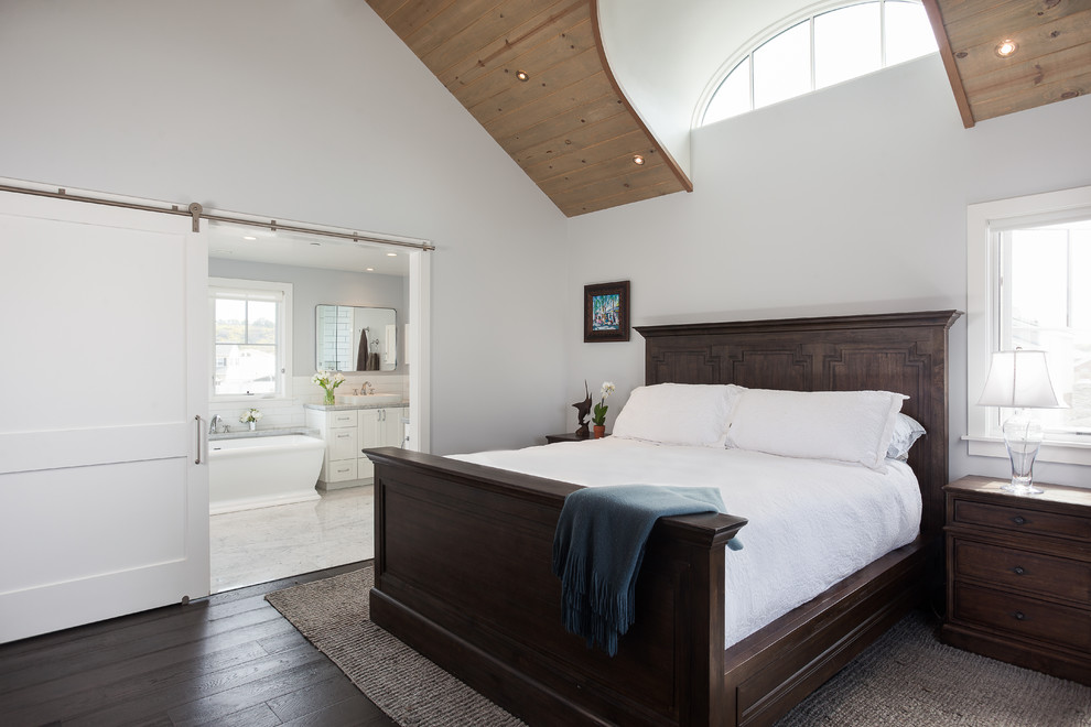 На фото: хозяйская спальня в морском стиле с белыми стенами, темным паркетным полом и коричневым полом