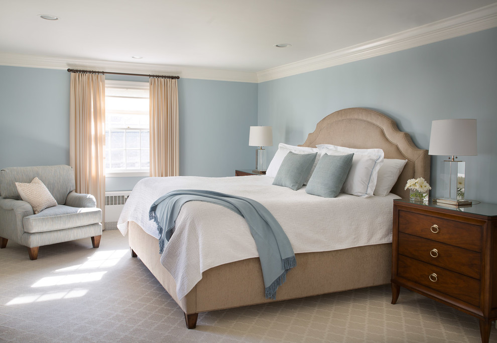 Modelo de dormitorio principal tradicional renovado grande sin chimenea con paredes azules y suelo de madera clara
