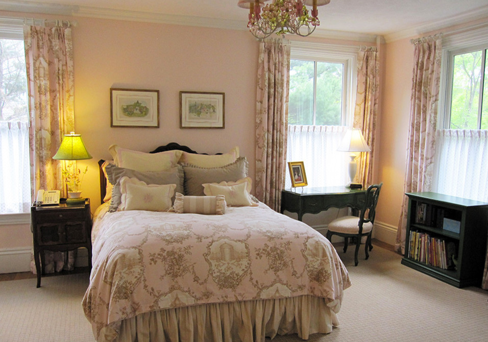 Modelo de habitación de invitados clásica de tamaño medio sin chimenea con paredes rosas y suelo de madera en tonos medios