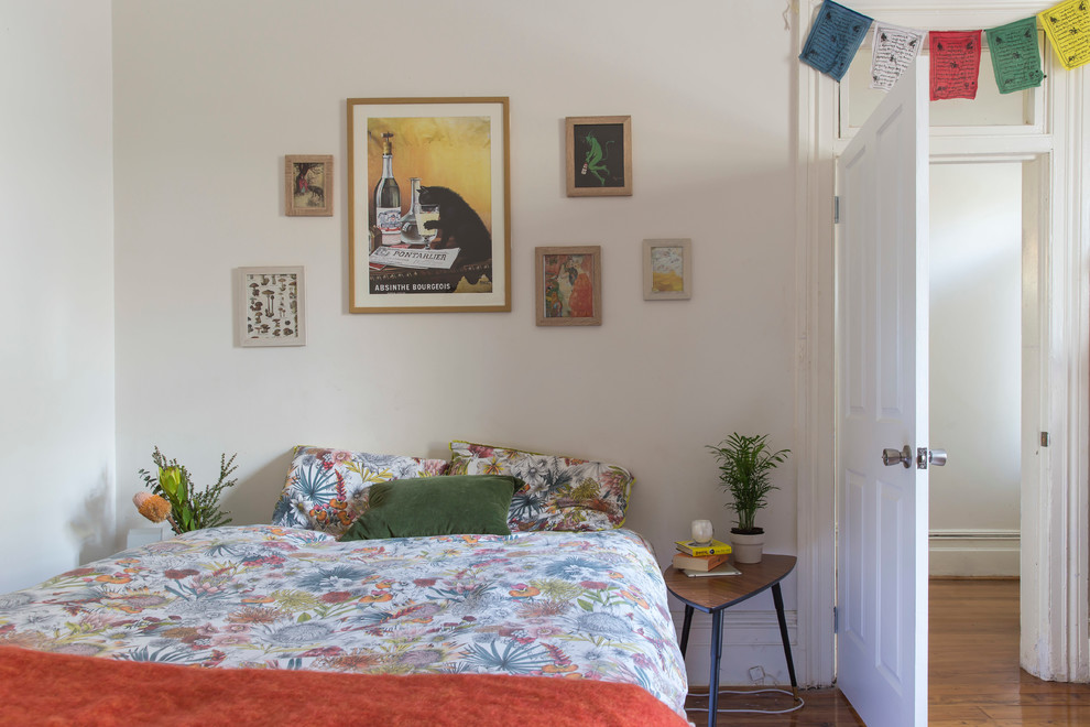 Ejemplo de dormitorio escandinavo con paredes blancas y suelo de madera en tonos medios