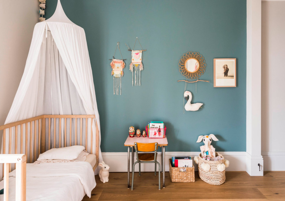 Inspiration pour une chambre design de taille moyenne avec un mur bleu et parquet clair.