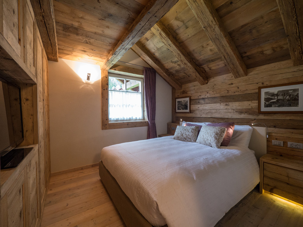 Modelo de dormitorio rural con paredes blancas y suelo de madera clara