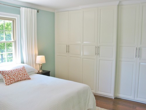 light turquoise walls with white bedding and white closet built ins