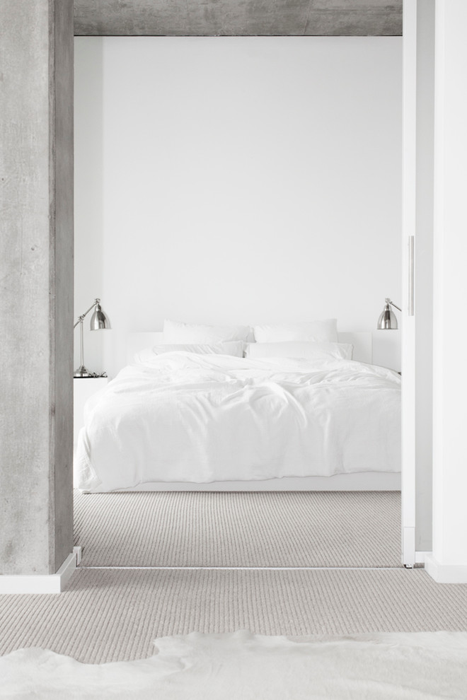 Cette image montre une chambre minimaliste de taille moyenne avec un mur blanc.